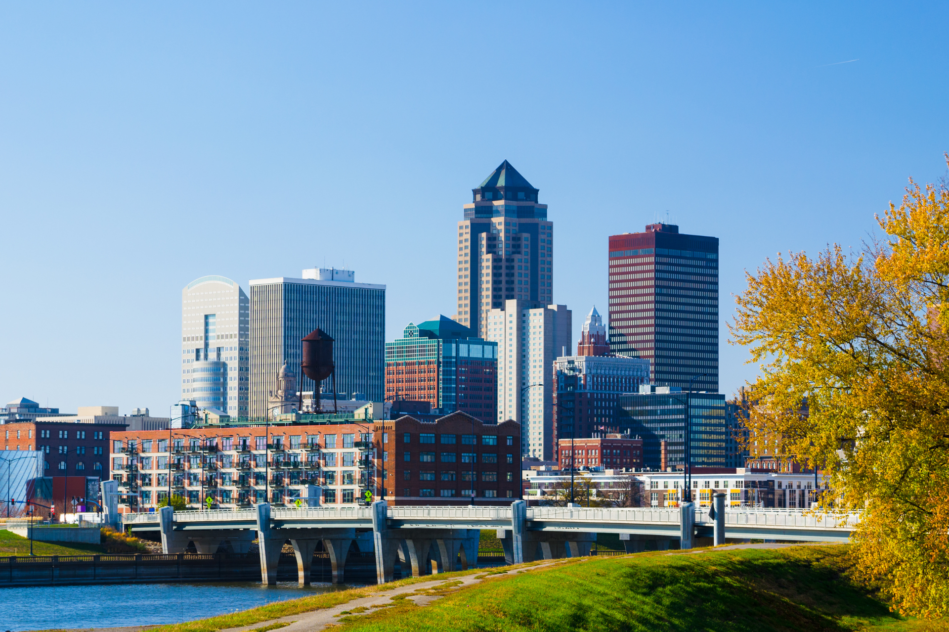 Des Moines city skyline and riverfront bridge on a sunny day